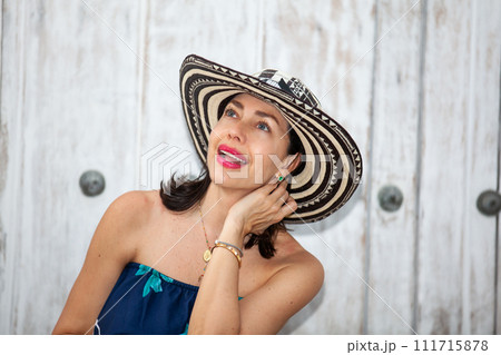 Beautiful woman wearing the traditional Colombian hat called Sombrero Vueltiao at the historical streets of the Cartagena de Indias walled city 111715878