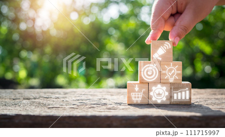 Advertising concept, Hand holding wooden block on desk with advertising icon on virtual screen. 111715997