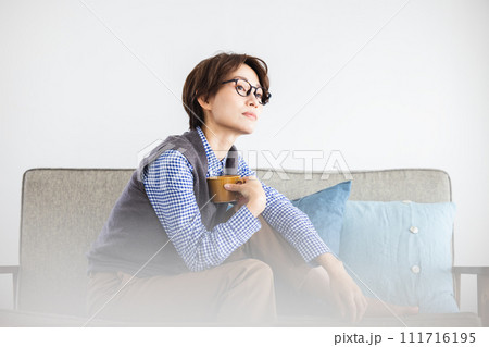 ソファーでコーヒーを飲む女性 ソファーでコーヒーを飲む女性 111716195