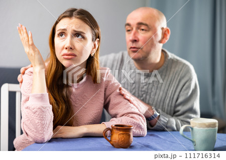 Man tries to comfort his upset wife Man tries to comfort his upset wife 111716314