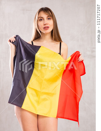 Attractive female football fan holding Germany flag Attractive female football fan holding Germany flag 111717207