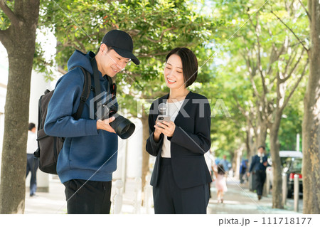 屋外で取材をするテレビ局のスタッフ 屋外で取材をするテレビ局のスタッフ 111718177