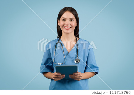Young female nurse in white coat with tablet smiles Young female nurse in white coat with tablet smiles 111718766