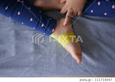 Elastic therapeutic yellow tape applied to child leg. Kinesio Taping therapy for injury 111719047
