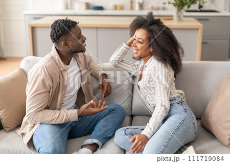 Happy African American Couple Talking Sitting On Sofa At Home Happy African American Couple Talking Sitting On Sofa At Home 111719084