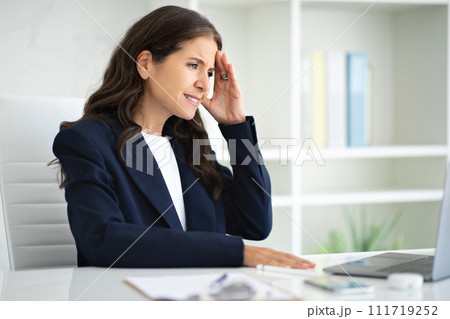 Sad middle aged woman working at office, suffering from headache Sad middle aged woman working at office, suffering from headache 111719252