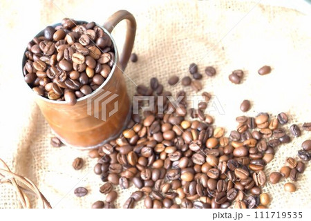 カップからこぼれる沢山のコーヒー豆 111719535