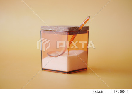 salt in a transparent jar on orange color background salt in a transparent jar on orange color background 111720006