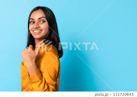 Middle Eastern Lady Pointing With Thumb At Blank Space, Studio 111720643