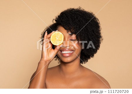 Joyful black woman with lemon, natural beauty theme 111720720