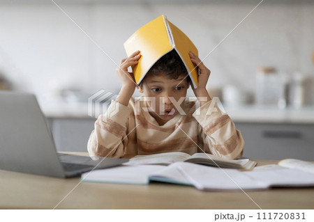 Homeschooling Problems. Stressed Black Boy Covering Head With Workbook While Doing Homework 111720831