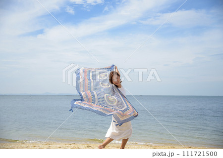 Cheerful asian woman barefoot walking on tropical summer beach. Woman walking along wave of sea water and sand on the beach. Enjoyment barefoot walk outdoor with freedom. Relaxation Travel Concept. Cheerful asian woman barefoot walking on tropical summer beach. Woman walking along wave of sea water and sand on the beach. Enjoyment barefoot walk outdoor with freedom. Relaxation Travel Concept. 111721500