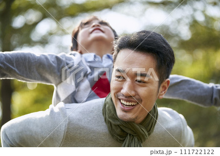 asian father and son having fun outdoors in park 111722122