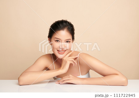 Beautiful young asian woman with clean fresh skin on beige background, Face care, Facial treatment, Cosmetology, beauty and spa, Asian women portrait. Beautiful young asian woman with clean fresh skin on beige background, Face care, Facial treatment, Cosmetology, beauty and spa, Asian women portrait. 111722945