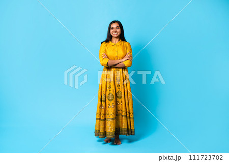 Smiling hindu lady wearing dress posing with folded arms, studio Smiling hindu lady wearing dress posing with folded arms, studio 111723702