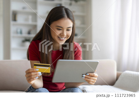 Online Shopping Concept. Smiling Asian Woman Using Digital Tablet And Credit Card Online Shopping Concept. Smiling Asian Woman Using Digital Tablet And Credit Card 111723965