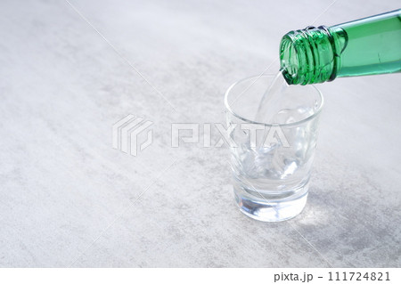 韓国の焼酎（ソジュ）をグラスに注ぐ 111724821