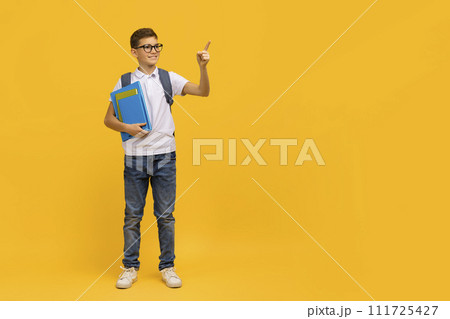 Educational Offer. Smiling Teen Schoolboy Holding Workbooks And Pointing Aside Educational Offer. Smiling Teen Schoolboy Holding Workbooks And Pointing Aside 111725427