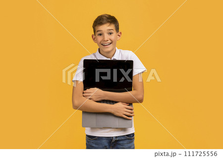 Tech Lover Concept. Cheerful Teen Boy Hugging Laptop With Blank Screen 111725556