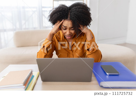 Unhappy despaired young curly african american woman student manager has stress with computer Unhappy despaired young curly african american woman student manager has stress with computer 111725732