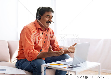 Middle aged indian man attending online webinar from home Middle aged indian man attending online webinar from home 111725769