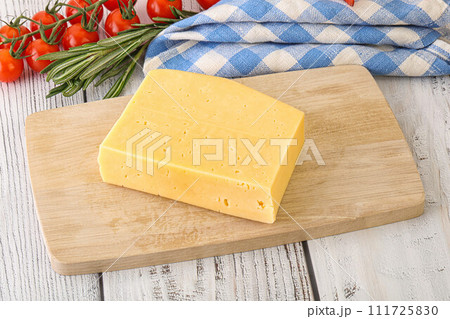 Piece of natural organic cheese over board 111725830