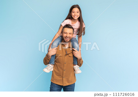 Happy Little Daughter Sitting On Dad's Shoulders Over Blue Background 111726016