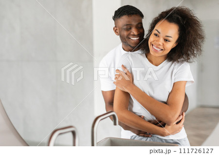 Loving African American couple embraces in their bathroom indoor 111726127