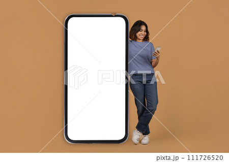 Middle eastern young woman stand next to big phone 111726520