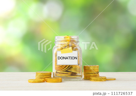 寄付金イメージ―DONATIONと書かれた瓶に入ったたくさんの金貨 寄付金イメージ―DONATIONと書かれた瓶に入ったたくさんの金貨 111726537