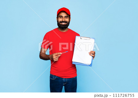 Indian delivery worker with clipboard on blue backdrop 111726755