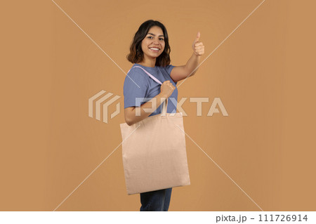Cheerful young middle eastern woman with shopping bag 111726914