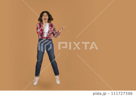 Amazed young middle eastern woman pointing at copy space 111727386