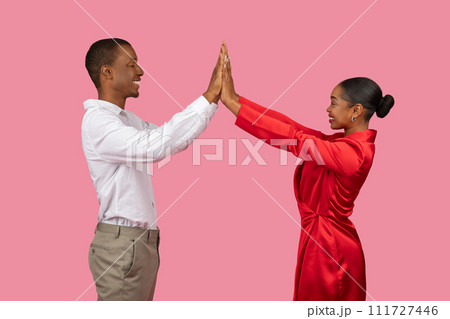 Happy black couple in white and red giving high-five, side view 111727446