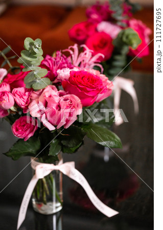 Vibrant Pink and Red Roses in Glass Vase on Black Background, Ideal for Valentines or Mothers Day 111727695