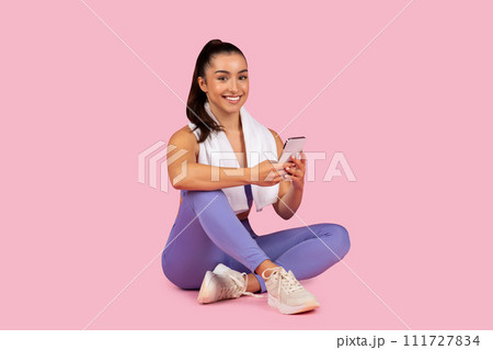 Young woman in sportswear using cellphone during workout break 111727834