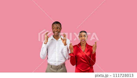 Hopeful black couple crossing fingers for good luck Hopeful black couple crossing fingers for good luck 111728013