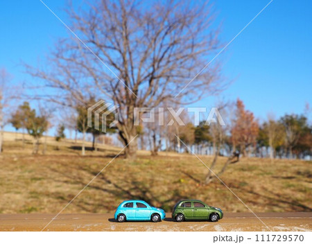 ミニカーのある風景　青空の公園とマーチ 111729570