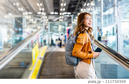 Young asian woman in international airport terminal or modern train station Young asian woman in international airport terminal or modern train station 111730309