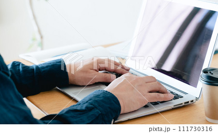 パソコンを操作する男性の手元 111730316