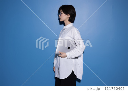 青背景で撮影をした眼鏡をかけた若い女性 111730403