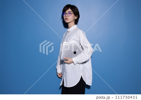 青背景で撮影をした眼鏡をかけた若い女性 青背景で撮影をした眼鏡をかけた若い女性 111730431