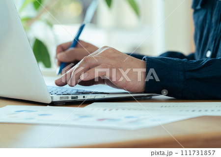 パソコンを操作する男性の手元 111731857