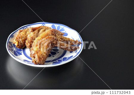 鶏の手羽先の唐揚げを黒背景で撮影 111732043