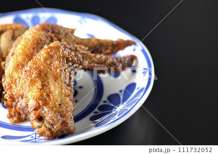 鶏の手羽先の唐揚げを黒背景で撮影 111732052