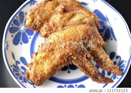 鶏の手羽先の唐揚げを黒背景で俯瞰撮影 111732123