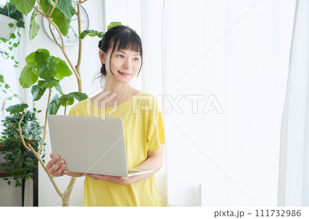 窓辺でパソコンを操作する女性 111732986