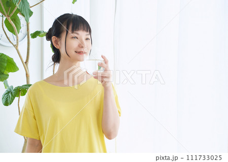 窓辺で水を飲む女性 窓辺で水を飲む女性 111733025