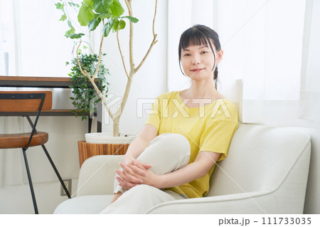 窓辺のソファーでくつろぐ女性 窓辺のソファーでくつろぐ女性 111733035