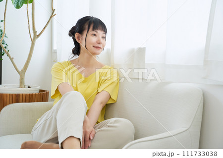 窓辺のソファーでくつろぐ女性 窓辺のソファーでくつろぐ女性 111733038